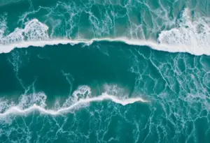 Aerial view of a coastal landscape affected by tsunami waves with research equipment in the foreground.