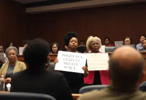 City council meeting discussing police settlement